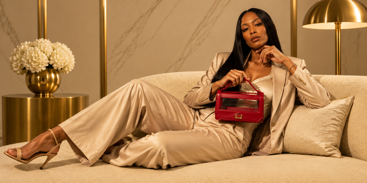 Woman holding an oxblood leather top-handle bag in the Glasshaus studio campaign